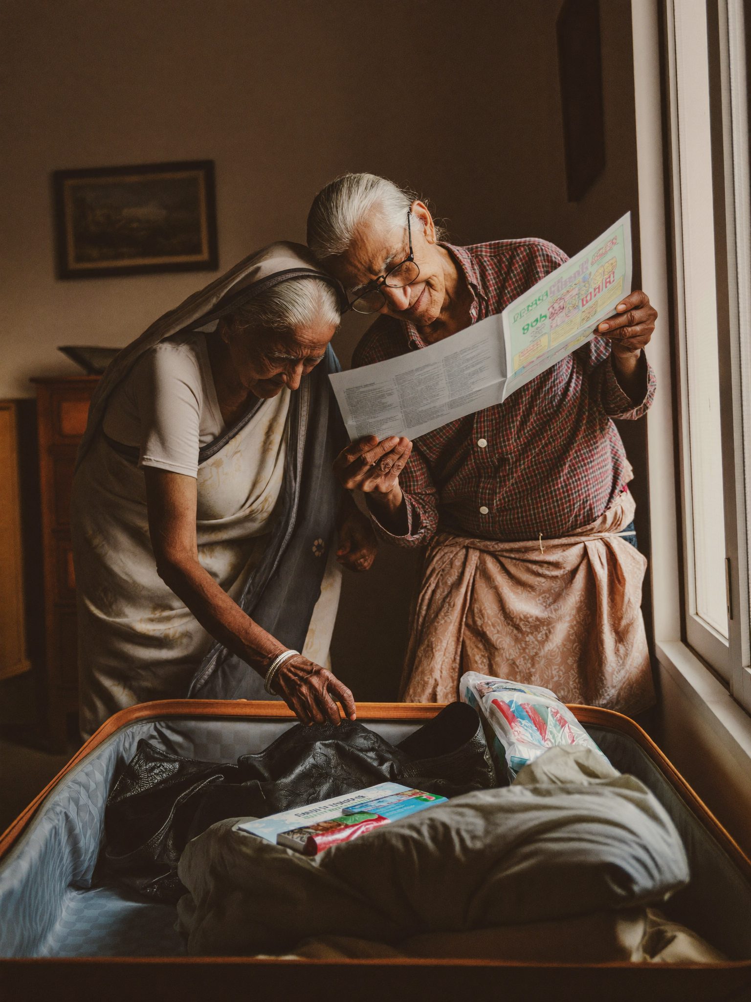 एक बुज़ुर्ग दंपति सफ़र के लिए अपना सामान पैक करते हुए